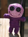 purple button eyed string voodoo doll